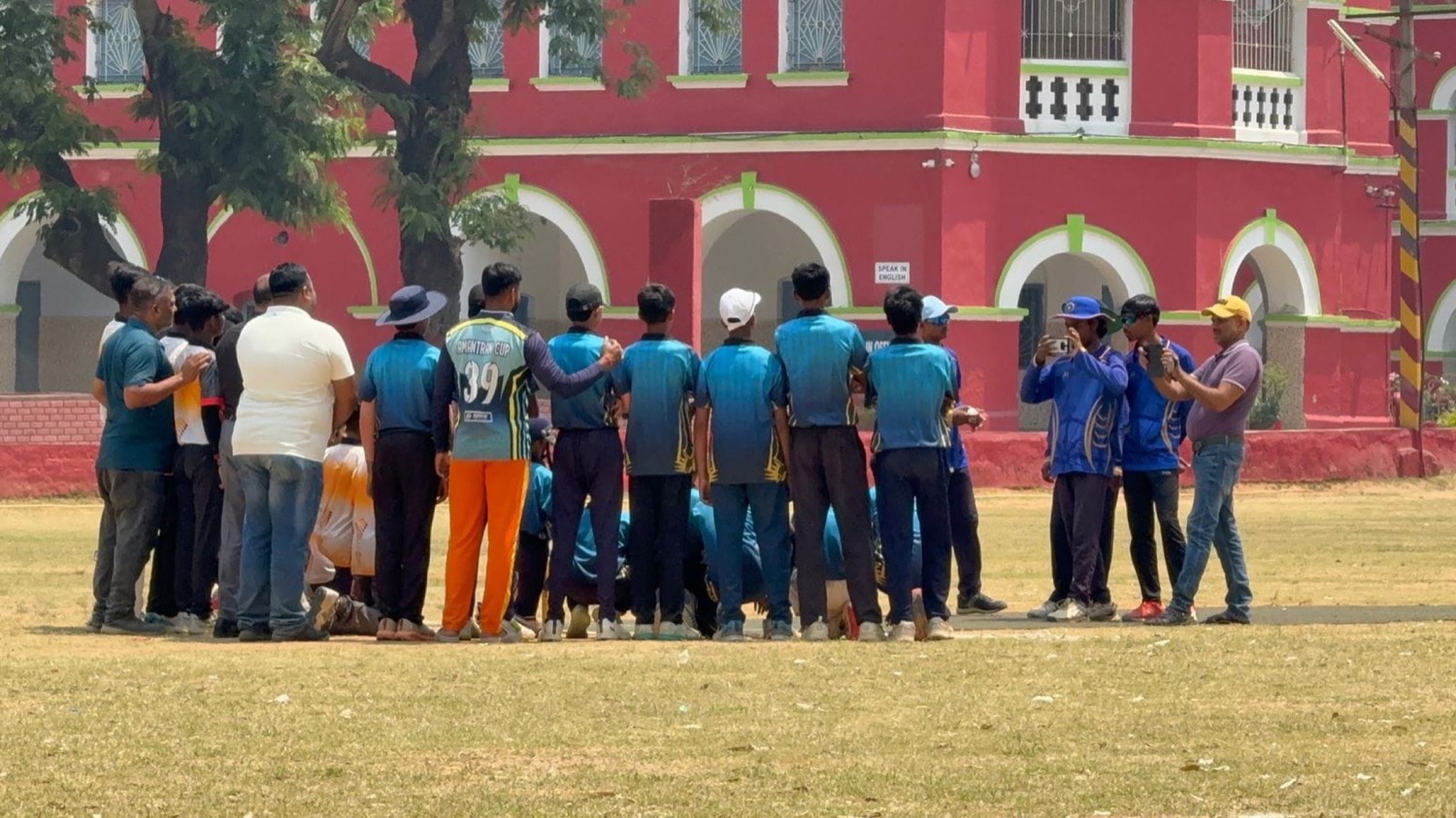 The team in a huddle in front of the red pavilion