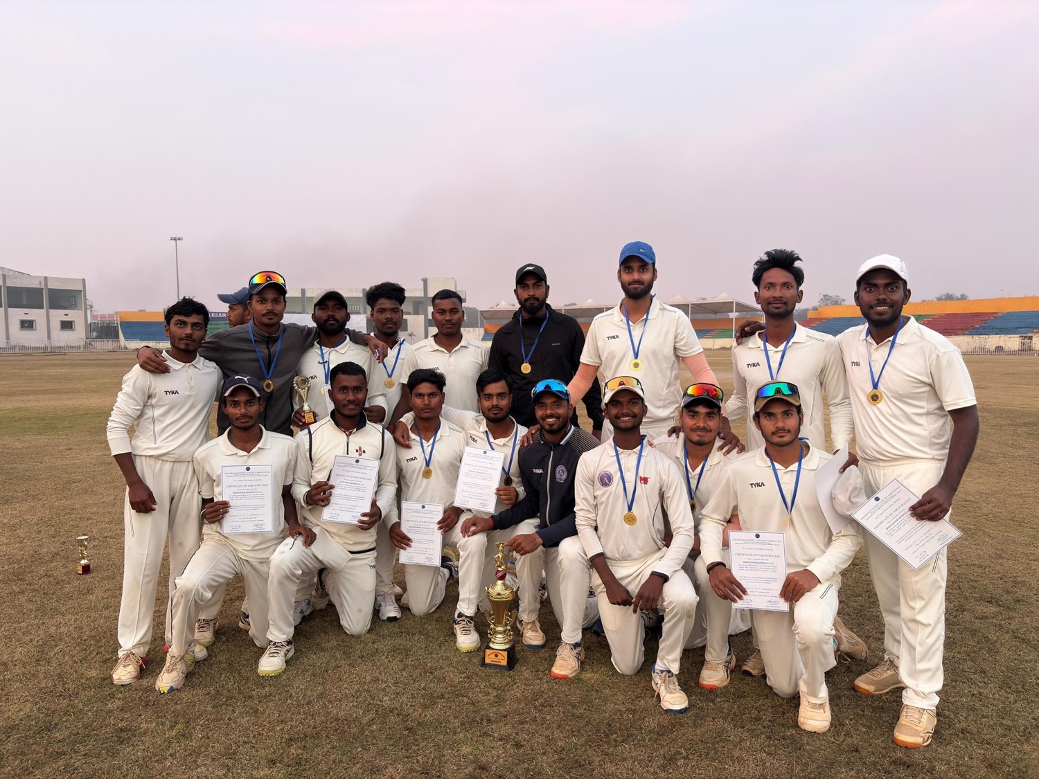 The team with medals, certificates and the winners trophy on the ground