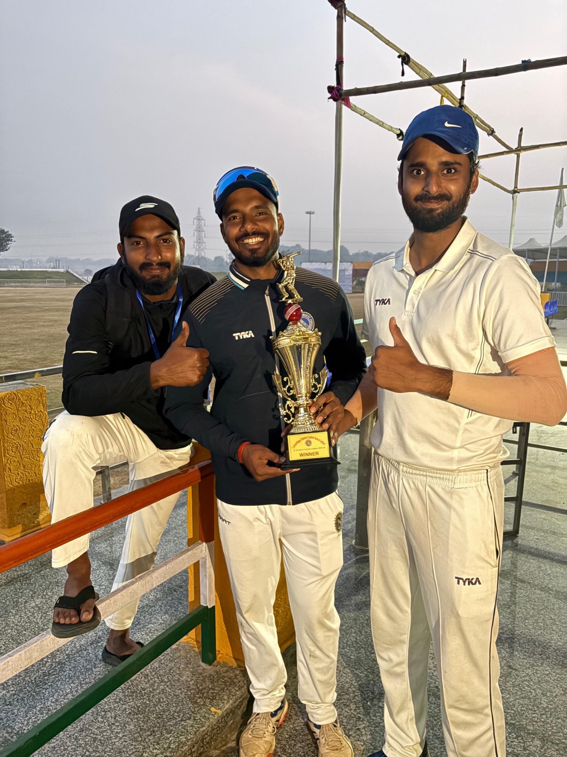 Three players holding the Lohardaga District Cricket Association winners trophy