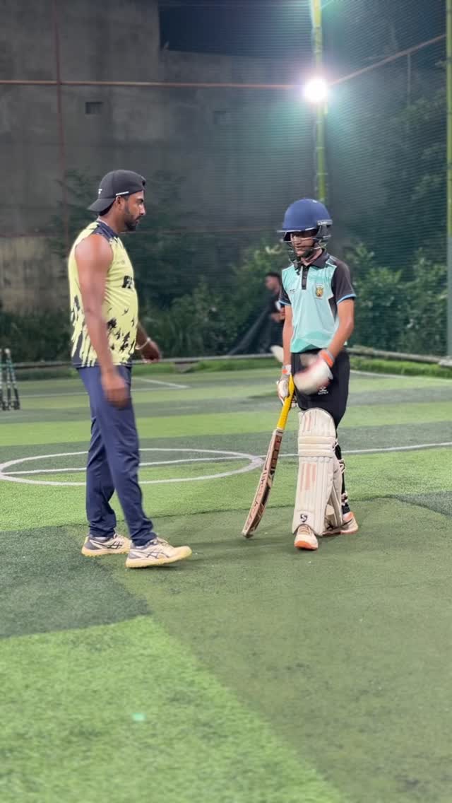 Coach working with a young batter in the nets