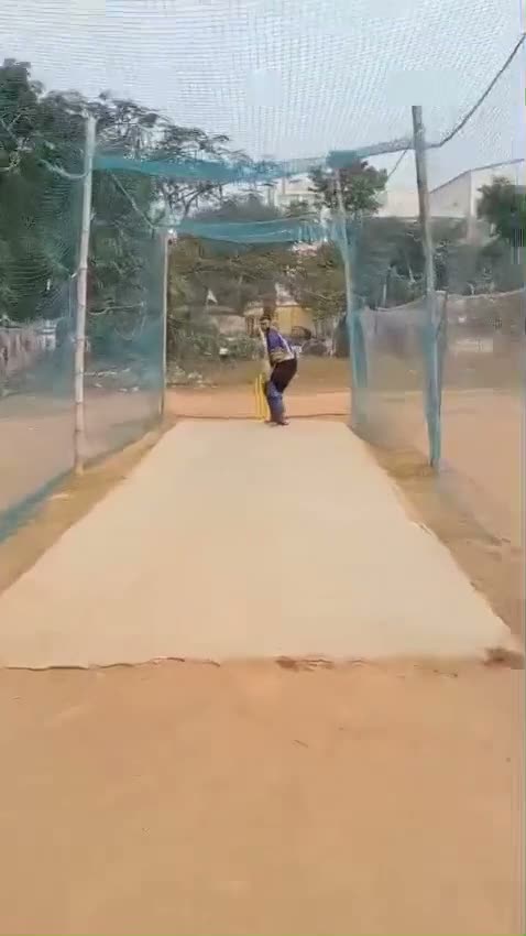 A batter facing up at the far end of the net